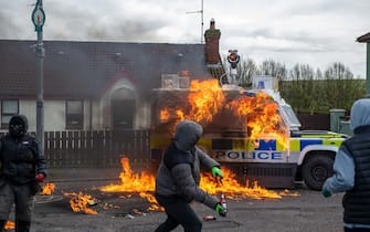 Members of the dissident republicans nationalist group throw petrol bombs at a police vehicle as they hold an anti-agreement rally on the 25th anniversary of the peace deal in Londonderry, also known as Derry, Northern Ireland, UK, on Monday, April 10, 2023. US President Joe Biden will visit Northern Ireland and the Republic of Ireland to coincide with the 25th anniversary of the signing of the Good Friday Agreement. Photographer: Chris J. Ratcliffe/Bloomberg