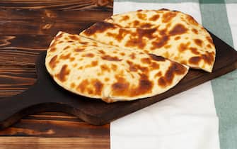 Baked homemade flatbread on wooden background close up photo
