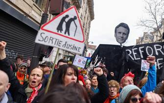 epaselect epa10507561 Protesters hold a banner showing French President Macron's face, during a protest against the French government's planned reform of the pension system, in Paris, France, 07 March 2023. The French government plans to delay the minimum retirement age from 62 to 64, until 2030.  EPA/MOHAMMED BADRA