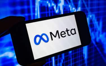 Digital composite image of Facebook Meta logo on phone scree.