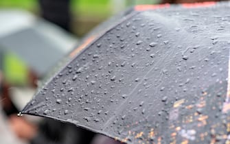 Raining Day, Heavy Rain in City, Drops on Surface of black Umbrella, People with Umbrellas during Storm