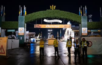 dpatop - 16 September 2023, Bavaria, Munich: Stewards stand at the main entrance during the prelude to the Oktoberfest opening. The first visitors wait at the main entrance for admission. The 188th Wiesn takes place this year from 16.09.- 03.10.2023. Photo: Sven Hoppe/dpa (Photo by Sven Hoppe/picture alliance via Getty Images)