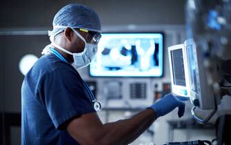 Shot of a surgeon looking at a monitor in an operating room