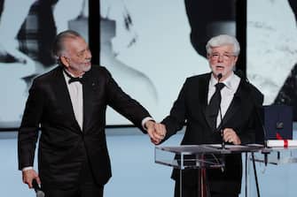 CANNES, FRANCE - MAY 25: George Lucas (R) receives the Honorary Palme Dâ  Or Award presented by Francis Ford Coppola (L) during the Closing Ceremony at the 77th annual Cannes Film Festival at Palais des Festivals on May 25, 2024 in Cannes, France. (Photo by Victor Boyko/Getty Images)