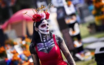 epa07968530 A visitor wearing a costume attends the Day of the Dead celebration at the Hollywood Forever Cemetery in Hollywood, Los Angeles, California, USA, 02 November 2019.  EPA/ETIENNE LAURENT