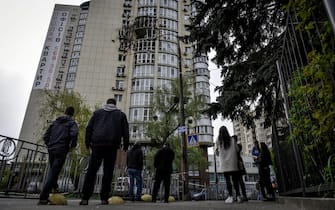 epa10614993 People look at an apartment block that was damaged by the debris of a Russian drone explosion in Kyiv, Ukraine, 08 May 2023. Russian troops entered Ukrainian territory in February 2022, starting a conflict that has provoked destruction and a humanitarian crisis.  EPA/OLEG PETRASYUK