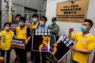 Pro-democracy activists tear a placard of Winnie-the-pooh that represents Chinese President Xi Jinping during a protest against a proposed new security law outside the Chinese Liaison Office in Hong Kong on May 24, 2020. - The proposed legislation is expected to ban treason, subversion and sedition, and follows repeated warnings from Beijing that it will no longer tolerate dissent in Hong Kong, which was shaken by months of massive, sometimes violent anti-government protests last year. (Photo by ISAAC LAWRENCE / AFP) (Photo by ISAAC LAWRENCE/AFP via Getty Images)
