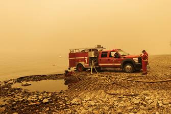 An Angelmont Fire Department truck pumps water for firefighting in Celista, British Columbia, Canada, on Saturday, Aug. 19, 2023. Record-breaking wildfires in Canada, which have already scorched an area larger than Greece, are heading toward key population centers, forcing tens of thousands to evacuate. Photographer: Cole Burston/Bloomberg via Getty Images