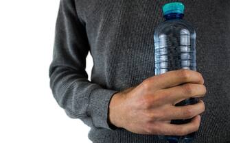 Bottiglia di plastica nelle mani di un uomo