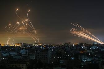 TOPSHOT - The Israeli Iron Dome missile defence system (L) intercepts rockets (R) fired by the Hamas movement towards southern Israel from Beit Lahia in the northern Gaza Strip as seen in the sky above the Gaza Strip overnight on May 14, 2021. - Israel bombarded Gaza with artillery and air strikes on Friday, May 14, in response to a new barrage of rocket fire from the Hamas-run enclave, but stopped short of a ground offensive in the conflict that has now claimed more than 100 Palestinian lives.
As the violence intensified, Israel said it was carrying out an attack "in the Gaza Strip" although it later clarified there were no boots on the ground. (Photo by ANAS BABA / AFP) (Photo by ANAS BABA/AFP via Getty Images)