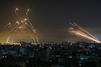 TOPSHOT - The Israeli Iron Dome missile defence system (L) intercepts rockets (R) fired by the Hamas movement towards southern Israel from Beit Lahia in the northern Gaza Strip as seen in the sky above the Gaza Strip overnight on May 14, 2021. - Israel bombarded Gaza with artillery and air strikes on Friday, May 14, in response to a new barrage of rocket fire from the Hamas-run enclave, but stopped short of a ground offensive in the conflict that has now claimed more than 100 Palestinian lives.
As the violence intensified, Israel said it was carrying out an attack "in the Gaza Strip" although it later clarified there were no boots on the ground. (Photo by ANAS BABA / AFP) (Photo by ANAS BABA/AFP via Getty Images)