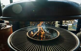 Round hearth for cooking. Brazier, barbecue in a restaurant for frying meat and vegetables on an open fire