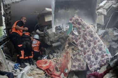 KHAN YUNIS, GAZA - OCTOBER 22: Palestinian emergency services and local citizens search for victims in buildings destroyed during Israeli air raids in the southern Gaza Strip on October 22, 2023 in Khan Yunis, Gaza. Gazans are evacuating to the south as advised by the Israeli government, ahead of an expected Israeli ground offensive. Israel has sealed off Gaza, leaving the entire population without fuel, water or aid, and launched sustained retaliatory air strikes, which have killed more than 2,000 people and some 400,000 displaced, after a large-scale attack by Hamas. On October 7, the Palestinian militant group Hamas launched a surprise attack on Israel from Gaza by land, sea, and air, killing over 1,300 people and wounding around 2,800. Israeli soldiers and civilians have also been taken hostage by Hamas and moved into Gaza. The attack prompted a declaration of war by Israeli Prime Minister Benjamin Netanyahu and the announcement of an emergency wartime government. (Photo by Ahmad Hasaballah/Getty Images)