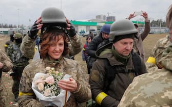 epa09805626 Ukrainian territorial defense fighters Valeriy (R) and Lesya (L) during their wedding ceremony at a blockpost near Kyiv (Kiev), Ukraine, 06 March 2022. Russian troops entered Ukraine on 24 February leading to a massive exodus of Ukrainians to neighboring countries as well as internal displacements.  EPA/SERGEY DOLZHENKO
