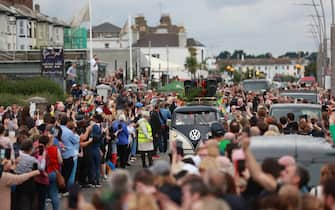 Fans of singer Sinead O'Connor line the streets for a "last goodbye" to the Irish singer as her funeral cortege passes through her former hometown of Bray, Co Wicklow, ahead of a private burial service. Picture date: Tuesday August 8, 2023.