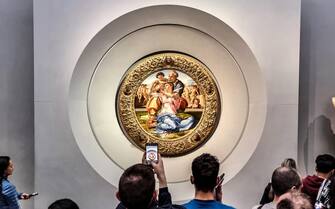 FLORENCE, ITALY - DECEMBER 30: Visitors look at and photograph the painting "Doni Tondo" The Holy Family with the Young St. John the Baptist, dated to about 1505 to 1507, by the Italian Renaissance artist Michelangelo di Lodovico Buonarroti Simoni, known as simply Michelangelo, at the Uffizi Gallery on December 30, 2022 in Florence, the capital of Italyâ  s Tuscany region. The 16th century museum is famous for its collection of ancient sculptures and its paintings that date from the Middle Ages to the Modern period. (Photo by David Silverman/Getty Images)