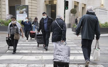 TURIN, ITALY - MAY 29: People wearing a protective mask walk crosswalk in the streets of the city center on May 29, 2020 in Turin, Italy. The Piedmont Region in complete autonomy declared that from today 29 May it is mandatory to use the protective mask even outdoors to prevent further infections from Coronavirus (Covid 19). Many Italian businesses have been allowed to reopen, after more than two months of a nationwide lockdown meant to curb the spread of Covid-19. (Photo by Stefano Guidi/Getty Images)