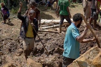 This undated handout photo taken by the UN Development Programme and released on May 28, 2024 shows locals digging at the site of a landslide at Mulitaka village in the region of Maip Mulitaka, in Papua New Guinea's Enga Province. Papua New Guinea moved to evacuate an estimated 7,900 people from remote villages near the site of a deadly landslide on May 28, as authorities warned of further slips. Some 2,000 people are already feared buried in a landslide that destroyed a remote highland community in the early hours of May 24. (Photo by Handout / UN DEVELOPMENT PROGRAMME / AFP) / RESTRICTED TO EDITORIAL USE - MANDATORY CREDIT "AFP PHOTO / UN DEVELOPMENT PROGRAMME  - NO MARKETING NO ADVERTISING CAMPAIGNS - DISTRIBUTED AS A SERVICE TO CLIENTS - NO ARCHIVE