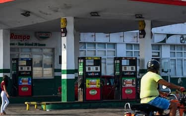 A man riding a motorcycle passes by an empty gas station in Havana on April 24, 2023. - "This is hell!" exclaims Lazaro Diaz, a 59-year-old Cuban courier who has been in line for a day hoping to get gasoline, in the longest fuel shortage crisis that Havanans say they have experienced in years. (Photo by YAMIL LAGE / AFP) (Photo by YAMIL LAGE/AFP via Getty Images)