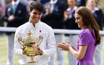 epaselect epa11477821 Carlos Alcaraz of Spain receives the trophy from Britain's Catherine, Princess of Wales after winning the Men's final against Novak Djokovic of Serbia at the Wimbledon Championships, Wimbledon, Britain, 14 July 2024.  EPA/TOLGA AKMEN  EDITORIAL USE ONLY