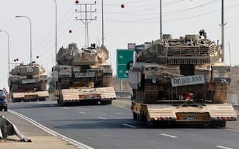 Israeli tanks are transported on a road near Sderot on October 8, 2023. Israel, reeling from the deadliest attack on its territory in half a century, formally declared war on Hamas on October 8, as the conflict's death toll surged to 1,000 after the Palestinian militant group launched a massive surprise assault from Gaza. (Photo by JACK GUEZ / AFP) (Photo by JACK GUEZ/AFP via Getty Images)