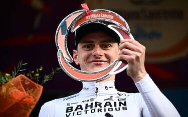 Team Bahrain's Matej Mohoric of Slovenia celebrates on the podium after winning the 113th Milan-San Remo one-day classic cycling race, on March 19, 2022 between Milan and San Remo, northern Italy. (Photo by Marco BERTORELLO / AFP)