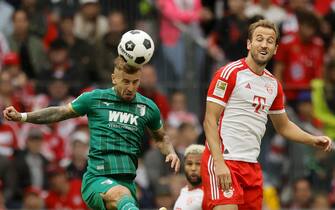 epa10823690 Munich's Harry Kane (R) in action against Augsburg's Niklas Dorsch (L) during the German Bundesliga soccer match between FC Bayern Munich and FC Augsburg in Munich, Germany, 27 August 2023.  EPA/RONALD WITTEK CONDITIONS - ATTENTION: The DFL regulations prohibit any use of photographs as image sequences and/or quasi-video.