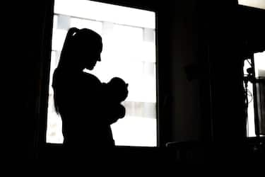 08 February 2024, Bremen: A woman stands with a newborn baby at the hospital window. Bremen wants to improve working conditions for nurses and midwives with a pilot project in a hospital. The "I'm nursing again because..." project was launched at the beginning of February at the St. Joseph-Stift hospital in Bremen. Over the next four years, the aim is to work with nurses and midwives to improve working conditions in the delivery room and maternity ward. Photo: Sina Schuldt/dpa (Photo by Sina Schuldt/picture alliance via Getty Images)