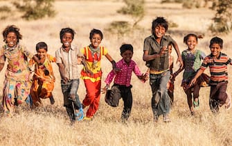 "Group of running happy Gypsy Indian children - desert village, Thar Desert, Rajasthan, India."