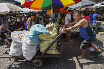epa06622440 A worker pushes a cart of waste from agriculture products at a market in Quezon City, east of Manila, Philippines, 23 March 2018. The World Bank on 23 March released a report titled 'The Challenge of Agricultural Pollution: Evidence from China, Vietnam and the Philippines' to lay out potential measures for cleaner and safer agriculture. Findings of the report reveal that while agriculture increases food security in East Asia, mismanaged agricultural production contributes to environmental degradation and reduced quality and safety of food.  EPA/ROLEX DELA PENA