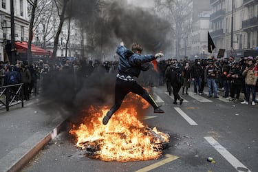 epa10547278 A protester jumps over a fire during a rally against the government's pension reform in Paris, France, 28 March 2023. France faces an ongoing national strike against the government's pensions reform after tthe French prime minister announced on 16 March 2023 the use of Article 49 paragraph 3 (49.3) of the French Constitution to have the text on the controversial pension reform law - raising retirement age from 62 to 64 - be definitively adopted without a vote.  EPA/CHRISTOPHE PETIT TESSON