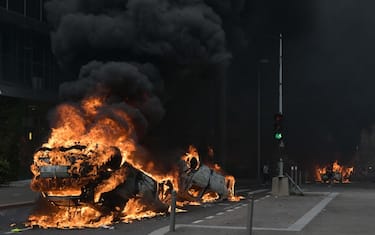 A photopraph shows cars burning in the street at the end of a commemoration march for a teenage driver shot dead by a policeman, in the Parisian suburb of Nanterre, on June 29, 2023. Violent protests broke out in France in the early hours of June 29, 2023, as anger grows over the police killing of a teenager, with security forces arresting 150 people in the chaos that saw balaclava-clad protesters burning cars and setting off fireworks. Nahel M., 17, was shot in the chest at point-blank range in Nanterre in the morning of June 27, 2023, in an incident that has reignited debate in France about police tactics long criticised by rights groups over the treatment of people in low-income suburbs, particularly ethnic minorities. (Photo by Alain JOCARD / AFP)