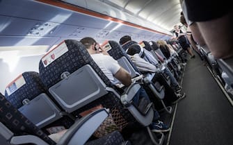Onboard an EasyJet flight, bound for Spain, showing the flight attendant walking the aisle.