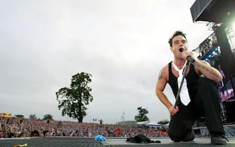 HERTFORDSHIRE, ENGLAND - AUGUST 1:  Singer Robbie Williams performs at Knebworth Park August 1, 2003 in Hertfordshire, England.  (Photo by Jon Furniss/Getty Images)