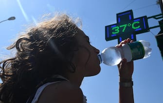 Una ragazza si disseta bevendo acqua fredda da una bottiglietta a Genova. 31  luglio 2018. Ondata di calore in Liguria con bollino rosso anche per il 2 agosto, prolungata dunque di altre 24 ore dal Ministero di Salute rispetto all'allerta diramato ieri. Arpal ha emesso un avviso meteorologico per avvertire dell'ondata di calore con elevato disagio a causa di temperature elevate e tassi d'umidità medio alti.    ANSA/LUCA ZENNARO