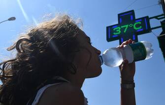 Una ragazza si disseta bevendo acqua fredda da una bottiglietta a Genova. 31  luglio 2018. Ondata di calore in Liguria con bollino rosso anche per il 2 agosto, prolungata dunque di altre 24 ore dal Ministero di Salute rispetto all'allerta diramato ieri. Arpal ha emesso un avviso meteorologico per avvertire dell'ondata di calore con elevato disagio a causa di temperature elevate e tassi d'umidità medio alti.    ANSA/LUCA ZENNARO