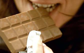ragazza addenta del cioccolato