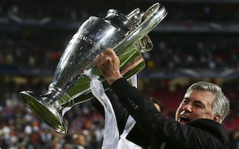epa04223490 Real Madrid's head coach Carlo Ancelotti celebrates with the trophy after the UEFA Champions League final between Real Madrid and Atletico Madrid at Luz stadium in Lisbon, Portugal, 24 May 2014. Real Madrid won 4-1 after extra time.  EPA/JOSE SENA GOULAO
