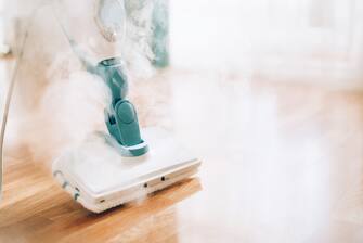 Steam cleaner mop cleaining floor. Banner with copy space. Cleaning service concept.