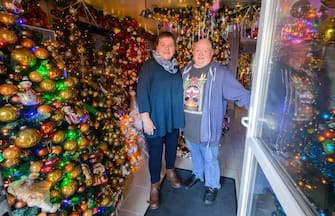 30 November 2023, Lower Saxony, Rinteln: Susanne and Thomas Jeromin stand amidst Christmas trees at the front door of their house in the Schaumburg district. 555 Christmas trees and almost 108,000 Christmas baubles: During Advent, the Jeromin family's house shines as a colorful Christmas world. Photo: Julian Stratenschulte/dpa (Photo by Julian Stratenschulte/picture alliance via Getty Images)