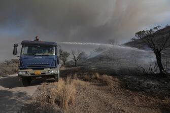Local residents attempt to extinguish a section of the wildfire on the Greek island of Rhodes, on July 26, 2023. Greece is currently grappling with rampant wildfires fueled by sweltering heat, leading to extensive evacuations in various tourist destinations, notably the islands of Rhodes and Corfu. (Photo by STR/NurPhoto via Getty Images)