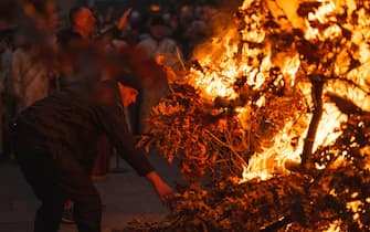 A man approaches a bonfire during the annual ceremony of bonfire of dried oak branches, the Yule log symbol for the Orthodox Christmas eve according to the Julian calendar, at the Church of Saint Sava in Belgrade on January 6, 2024. (Photo by Andrej ISAKOVIC / AFP) (Photo by ANDREJ ISAKOVIC/AFP via Getty Images)