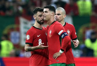 epa11451295 Cristiano Ronaldo of Portugal (R) reacts with teammates Bruno Fernandes (L) and Pepe after failing to score by penalty during the UEFA EURO 2024 Round of 16 soccer match between Portugal and Slovenia, in Frankfurt Main, Germany, 01 July 2024.  EPA/ANNA SZILAGYI
