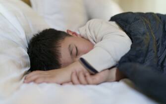 A little boy was tired and fell asleep in the hotel