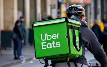 Cardiff, Wales - March 2022: Cycle courier for the Uber Eats food delivery service riding through the city centre