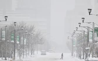 DES MOINES, IA - JANUARY 12: A pedestrian crosses the street during blizzard conditions ahead of the Iowa Caucuses on January 12, 2024 in Des Moines, IA. (Photo by Ricky Carioti/The Washington Post via Getty Images)