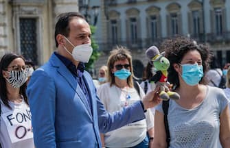 Coronavirus Covid 19 fase 2. Il presidente dela Regione Piemonte Alberto Cirio riceve un grillo parlante da una rappresentante dei dipendenti degli asili nido privati che protestano sotto la Regione Piemonte in piazza Castello. Torino 21 maggio 2020 ANSA/TINO ROMANO