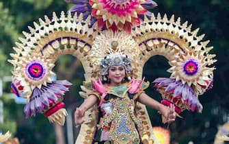 epa11050344 Balinese dancers perform as they take part in a cultural parade, during a new year's eve celebration at a main road in Denpasar, Bali, Indonesia, 31 December 2023.  EPA/MADE NAGI
