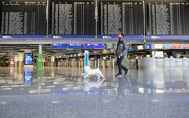 27 March 2023, Hesse, Frankfurt/Main: As his flight to Paris was canceled, a man walks his dog through the otherwise deserted terminal of Frankfurt Airport. With a large-scale nationwide warning strike, the EVG and Verdi unions paralyzed large parts of public transport on Monday. Photo: Boris Roessler/dpa (Photo by Boris Roessler/picture alliance via Getty Images)