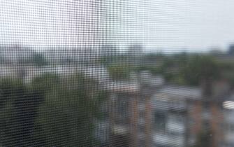 Blurred view of the city through an insect mesh on a house or apartment window. A mosquito net. Protection of housing from insects. Safety.